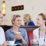 Three friends drinking coffee in a cafe