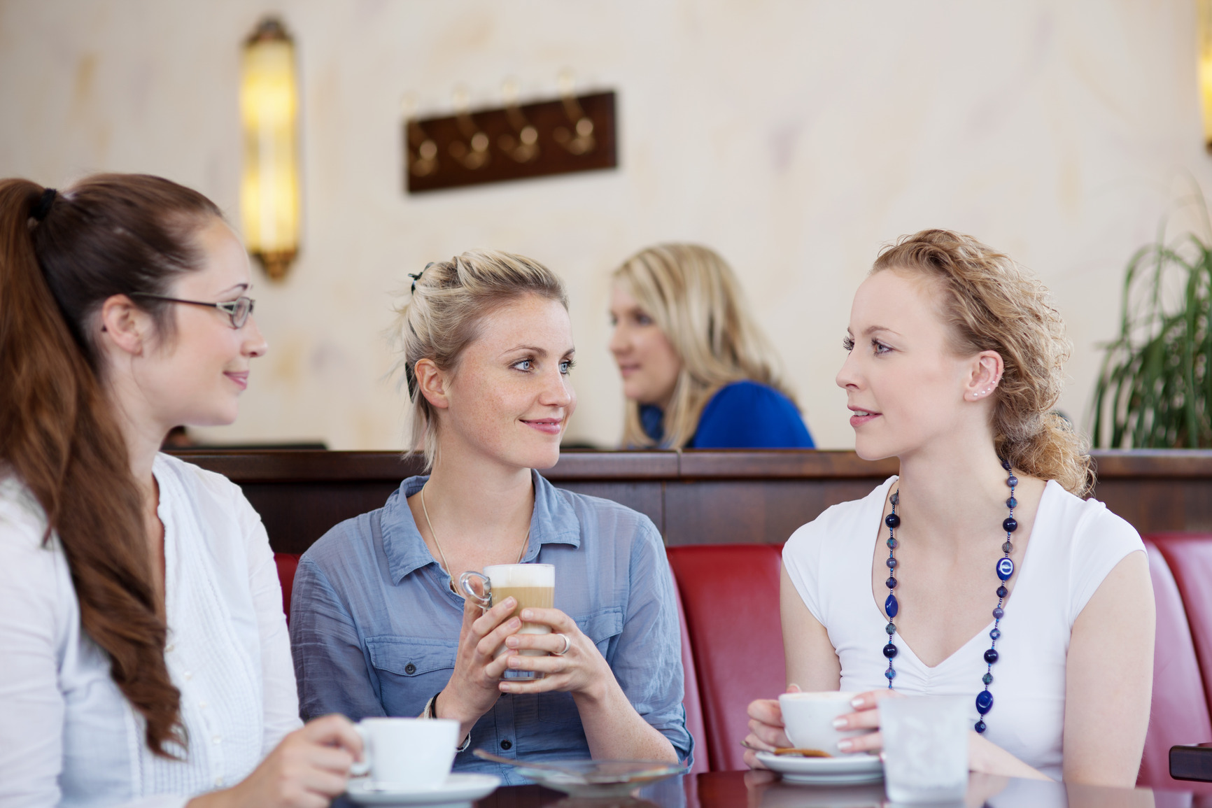 Three friends drinking coffee in a cafe